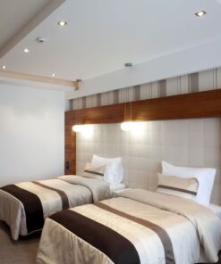 Διακοσμητικό φωτιστικό δωματίου με μοντέρνο σχεδιασμό, κρεμαστό πάνω από δύο κρεβάτια.