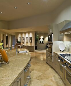 Σύγχρονη κουζίνα με γωνιακές ηλεκτρικές εστίες, φούρνο και inox απορροφητήρα, σε ουδέτερες αποχρώσεις.