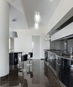 Μοντέρνα μαύρα ντουλάπια κουζίνας με γυαλιστερό φινίρισμα και ανοξείδωτες συσκευές σε πολυτελή κουζίνα.