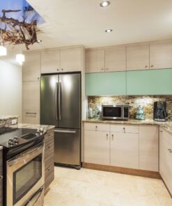 Σύγχρονη κουζίνα με ανοξείδωτες συσκευές, φούρνος, ψυγείο, φούρνος μικροκυμάτων και μηχανή καφέ. Διακόσμηση ξύλου.