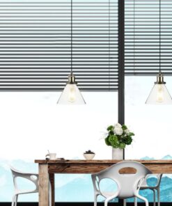 Τραπεζαρία με ξύλινο τραπέζι, μοντέρνες καρέκλες και φωτιστικά, φόντο με ορεινό τοπίο και περσίδες.