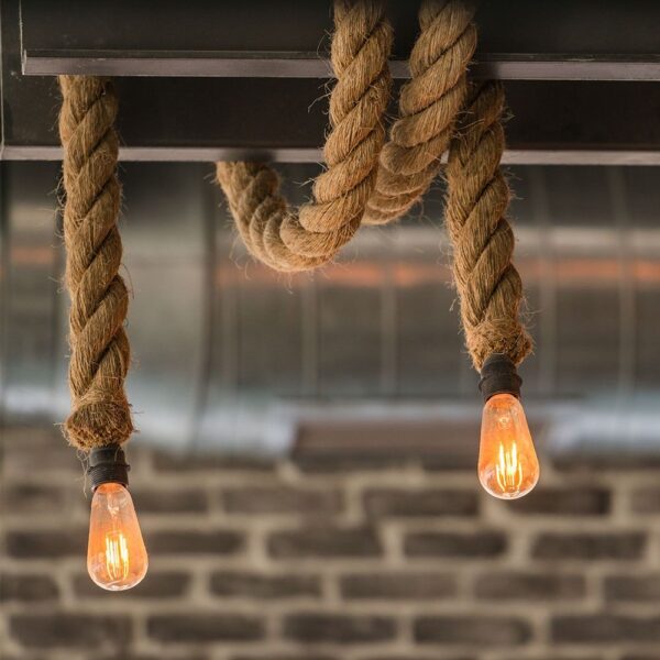Κρεμαστά σχοινιά με λαμπτήρες Edison σε industrial περιβάλλον, δημιουργώντας ρουστίκ διακόσμηση.