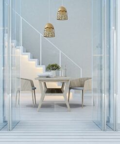 Μοντέρνα τραπεζαρία με ξύλινο τραπέζι και καρέκλες, φωτιστικά και διακόσμηση με σκάλες στο βάθος.