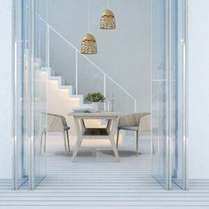 Μοντέρνα τραπεζαρία με ξύλινο τραπέζι και καρέκλες, φωτιστικά και διακόσμηση με σκάλες στο βάθος.