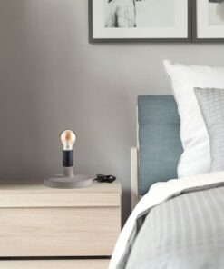 Κομοδίνο με μοντέρνα λάμπα, σε minimal υπνοδωμάτιο με γκρι και λευκή διακόσμηση.