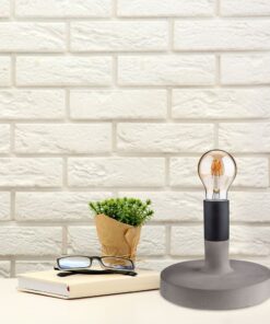 Λευκό τούβλινο φόντο με επιτραπέζιο λαμπτήρα, βιβλίο και γυαλιά, μοντέρνα γραφείο διακόσμηση.