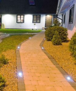 Ηλιακά φώτα διαδρόμου εξωτερικού χώρου για φωτεινότητα τη νύχτα, τοποθετημένα σε πλακόστρωτο μονοπάτι.